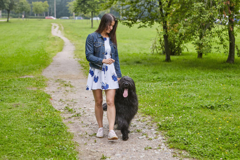 Eine Frau geht mit ihrem Hund gassi
